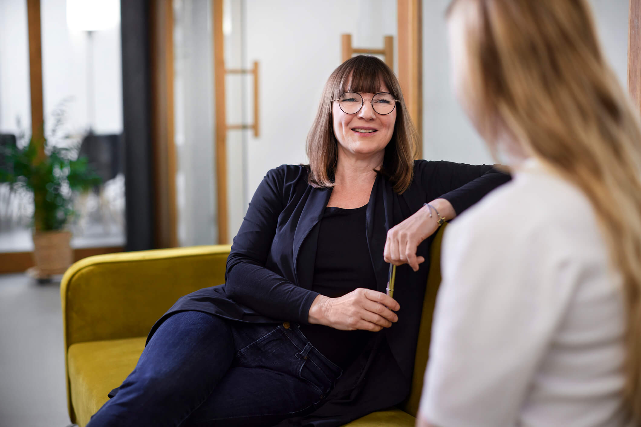 two woman discussing personal goals on couch